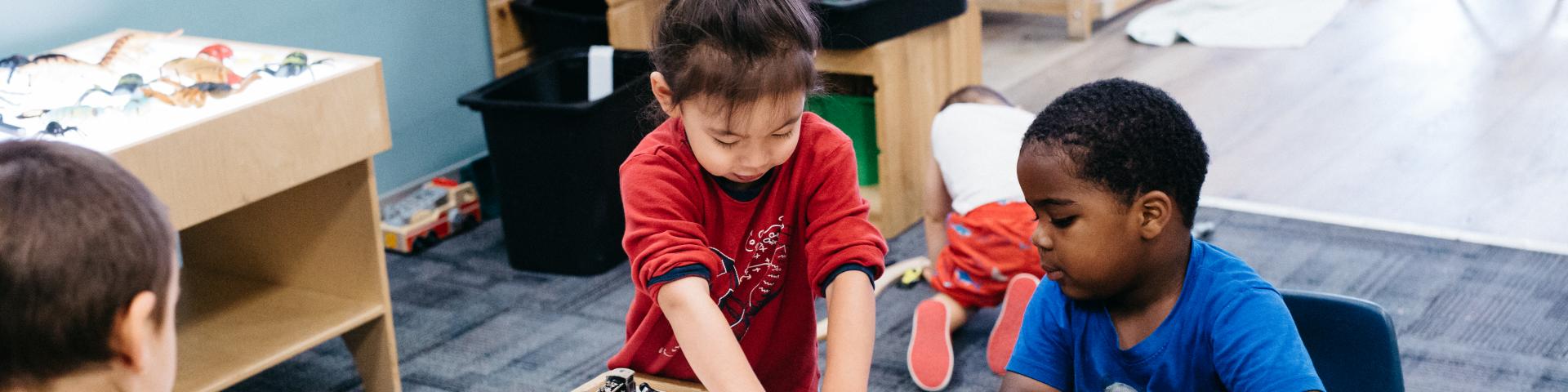 Children and care giver play at YWCA Crabtree Corner Child Care Centre