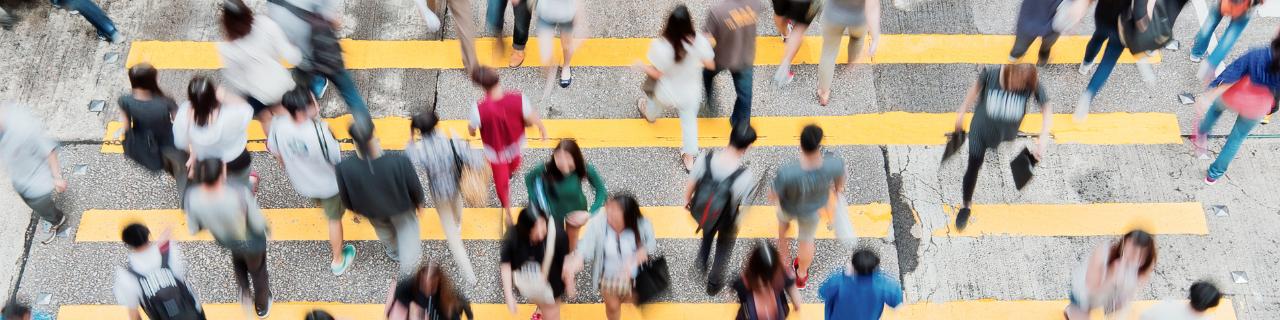 Multiple people crossing a busy city street 