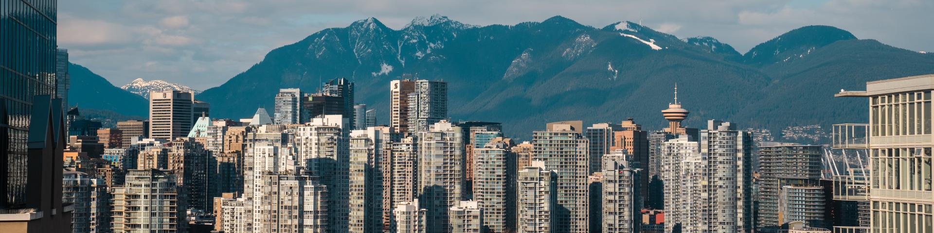 A skyline of Vancouver City, with the mountains in the background