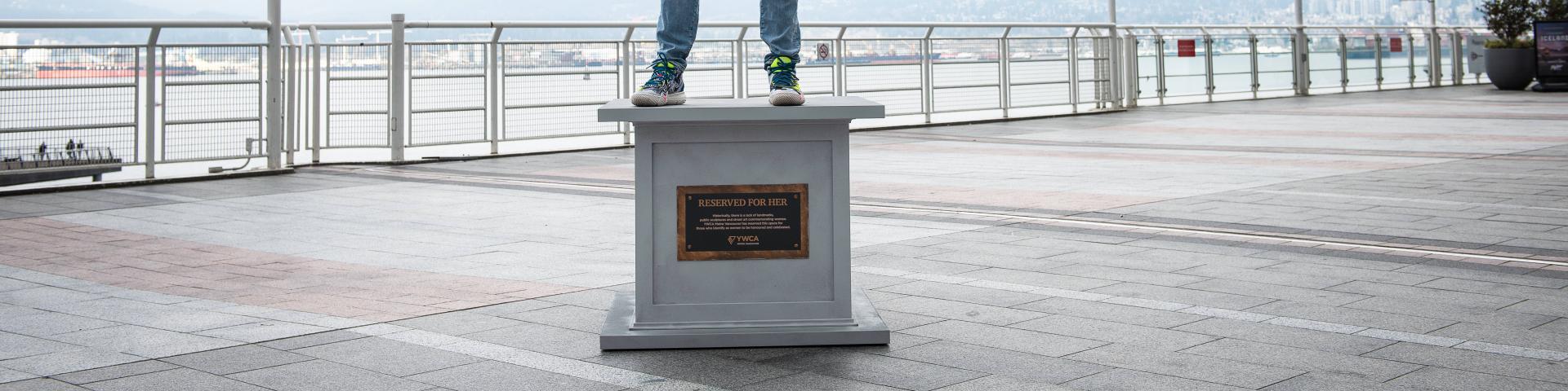 woman poses on statue base