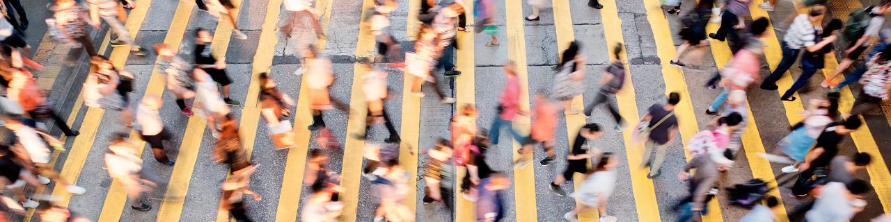 Multiple people crossing a busy street