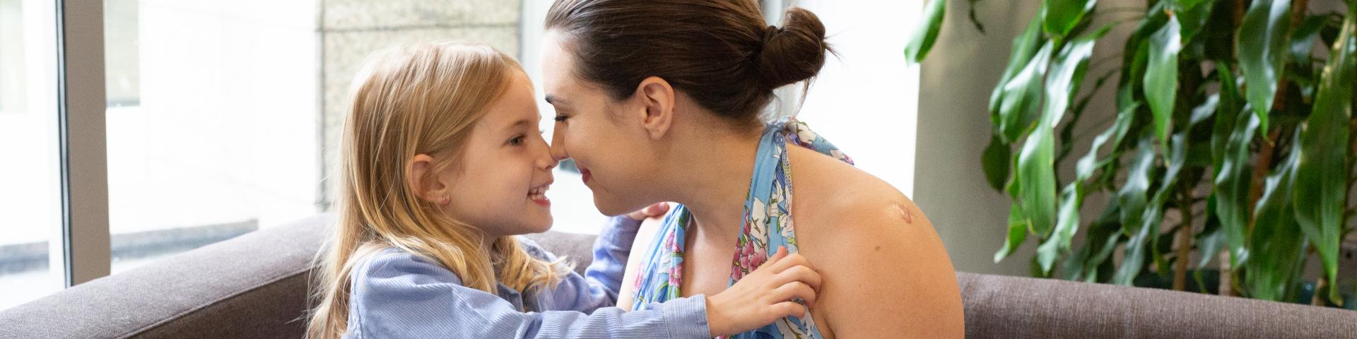 Mother and daughter looking at each other in the eyes, smiling