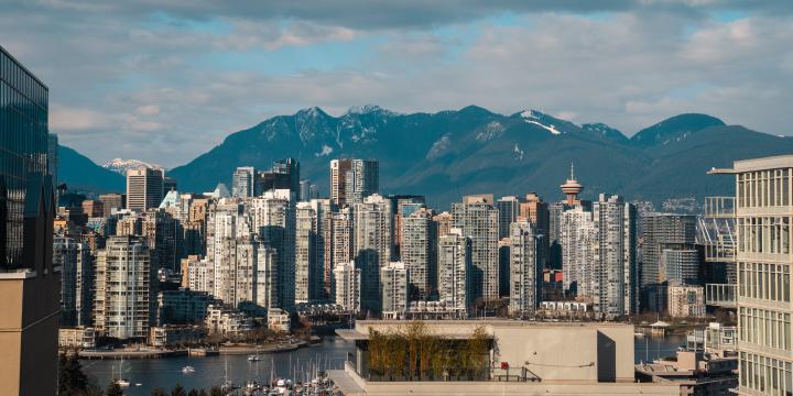 A skyline of Vancouver City, with the mountains in the background