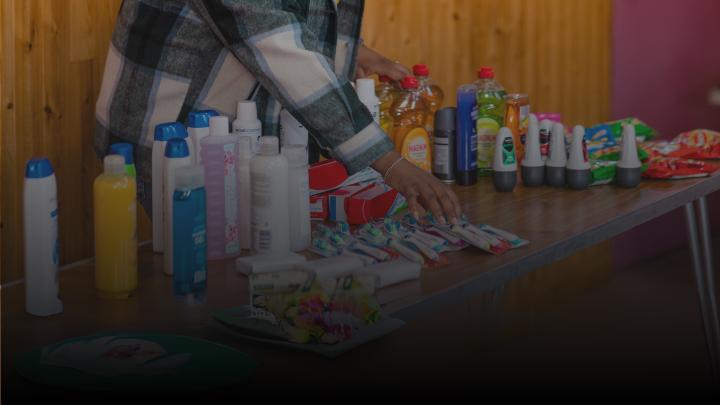 Women setting up table with toiletries for donation