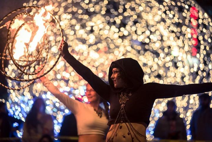 Photo of fire performer in front of an illumination and light display at Lumière Festival Vancouver