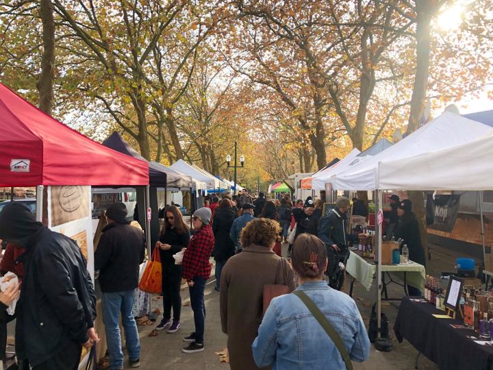 Photo of Hasting Park Farmers Market with tents and booths and people walking through during the day