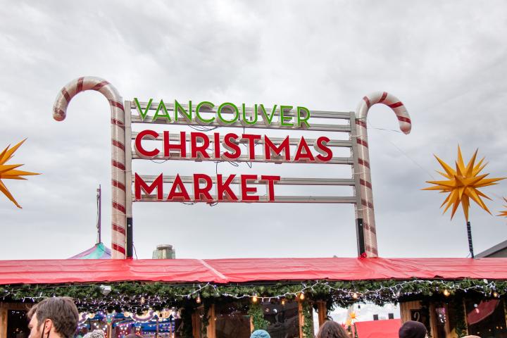 Photo of the entrance sign of the Vancouver Christmas market that is adorned by two candy canes on each side.