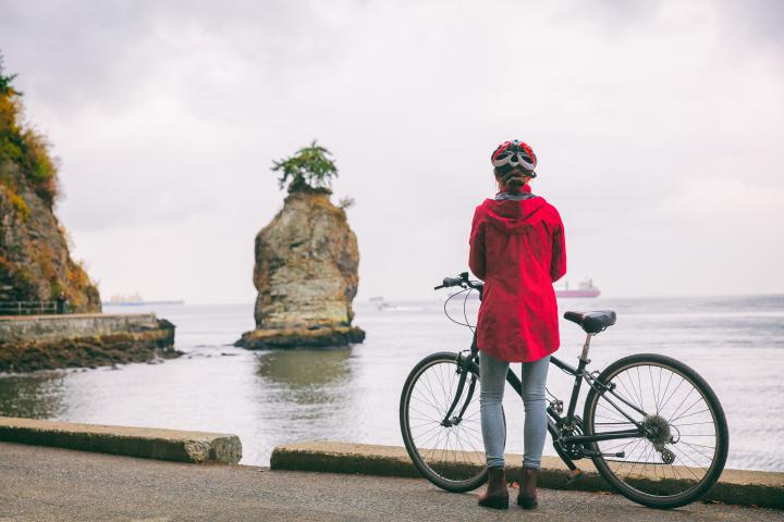 Photo of women with a bicycle along the Vancouver Stanley Park seawall during the fall
