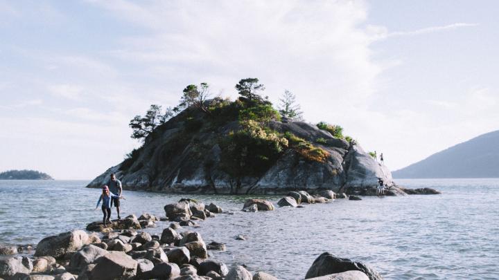 Rocks along the ocean trailing to a small island at Whytecliff Park