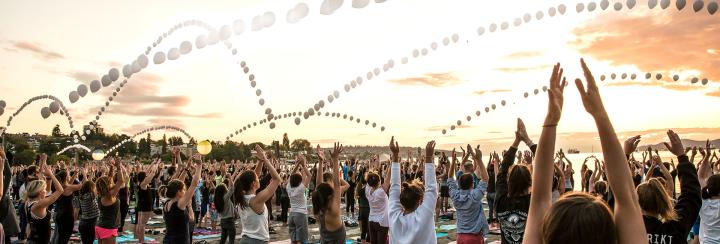 Photo of a crowd of people practicing Yoga at Kits Fest