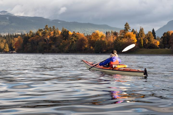 Person kayaking with the view of Vancouver fall trees