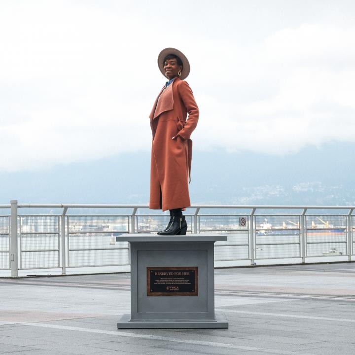 woman posing on statue base